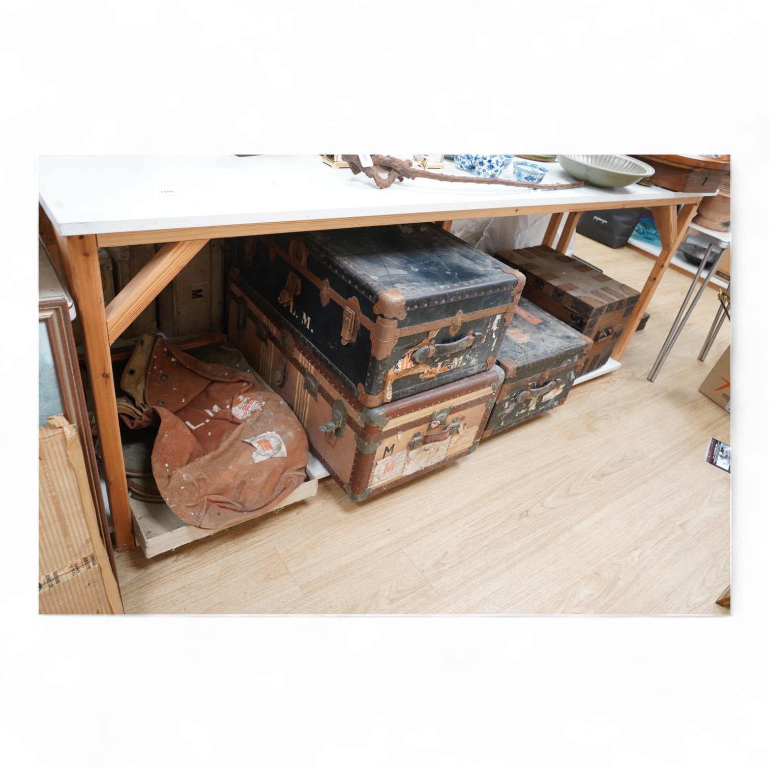 A collection of vintage luggage comprising four early 20th century bound travelling trunks and three kit bags